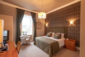 Habitación de hotel con cama y silla en The Royal Hotel en Bideford