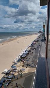 - une vue aérienne sur une plage avec des parasols et des personnes dans l'établissement Lovely n° 9 op ieder moment een prachtig zeezicht & zwembad, à Middelkerke
