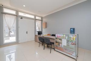 a kitchen with a refrigerator and chairs in it at Urbanview Hotel Stariez Karawaci Tangerang by RedDoorz in Tangerang