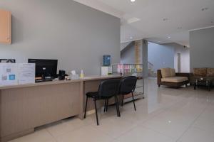 a lobby with a reception desk with chairs and a couch at Urbanview Hotel Stariez Karawaci Tangerang by RedDoorz in Tangerang
