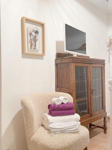 Habitación con silla y TV en un armario. en Agriturismo "Le Cannelle" spa & day wellness, en Fossombrone