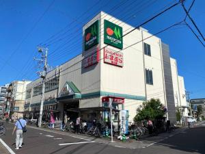 un edificio en una calle con gente caminando delante de él en 1min walk to sta, drct bus to HND! Easy access! 03 en Tokio