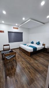 duża sypialnia z 2 łóżkami i stołem w obiekcie My Kingdom Munnar w mieście Munnar