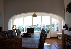 ein Esszimmer mit einem Tisch und Stühlen sowie einem großen Fenster in der Unterkunft Robis Moraira in Benissa