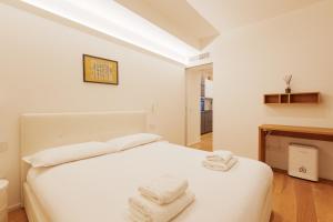 a bedroom with a white bed with towels on it at Chic & Modern Flat just 450 mt from Centrale FS in Milan