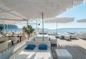 a restaurant with white chairs and tables and the ocean at Robis Moraira in Benissa