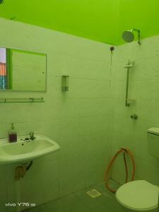 De' Aman Homestay في جيترا: حمام مع حوض ومرحاض