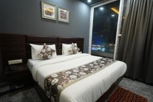 een slaapkamer met een groot bed en een raam bij Posh Garden Inn Artemis Hospital Road Gurgaon in Gurgaon