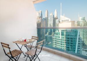 a table and chairs on a balcony with a view of the city at Manzil - 1BR Home in Dubai Marina with Marina View, Nr JBR Beach & Marina Mall in Dubai
