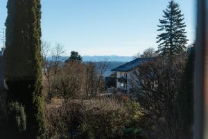 a house on a hill with a tree in the foreground at Ferienwohnung am Starnberger See in Feldafing