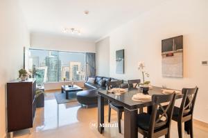 a living room with a table and a couch at Manzil - 1BR Home in Dubai Marina with Marina View, Nr JBR Beach & Marina Mall in Dubai