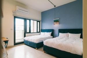 1 dormitorio con 2 camas y pared azul en Coffee&Drinks bnb公主咖啡, en Hualien City