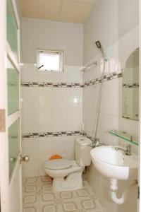 a white bathroom with a toilet and a sink at Lucky Home in Nha Trang