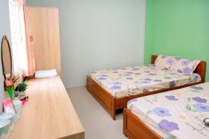 a small room with two beds and a table at Lucky Home in Nha Trang