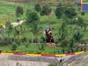 Un homme sautant en l'air sur une tyrolienne dans l'établissement LiLLA Summer Retreats formerly known as Karak Orchard Resort, à Kampung Sunjai Gapoi