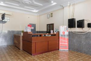 a waiting room with a reception desk and avertisement for at RedDoorz Syariah near Suzuya Mall Banda Aceh in Banda Aceh