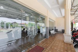 a lobby with a glass wall with a table and chairs at RedDoorz Syariah near Suzuya Mall Banda Aceh in Banda Aceh