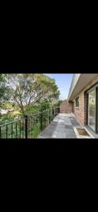 a picture of a building with a fence and a tree at Hidden Gem North Sydney in Sydney