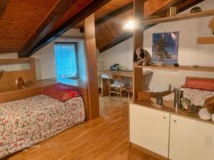a bedroom with a bed and a desk in a room at La Casa dei Nonni in Arta Terme