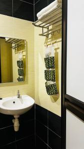een badkamer met een wastafel en een spiegel bij SiN LiEN HOTEL in Kluang