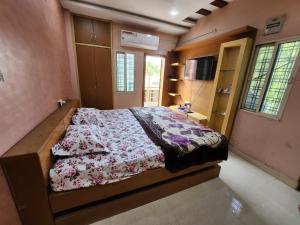 a bedroom with a bed with a floral comforter at SCK Home Stay in Hyderabad