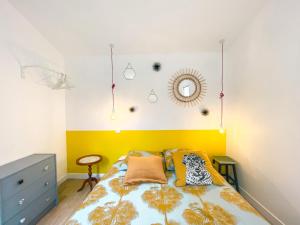 een slaapkamer met een bed met een geel hoofdeinde bij Ilbarritz, T2 proche plage/parking/terrasse in Bidart