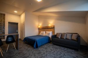 Habitación de hotel con cama y sofá en Loft Inn SELF-CHECK IN en Vilna