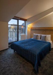 a bedroom with a large bed with a blue comforter at Loft Inn SELF-CHECK IN in Vilnius