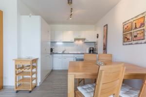 eine Küche und ein Esszimmer mit einem Holztisch in der Unterkunft Appartementanlage Likedeeler, Ferienwohnung 41 in Boltenhagen