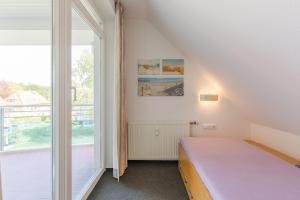 ein Schlafzimmer mit einem Bett und einem großen Fenster in der Unterkunft Appartementanlage Likedeeler, Ferienwohnung 41 in Boltenhagen
