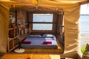 una cama en la parte trasera de una tienda en Firefly Eco Retreat, en Shimoni