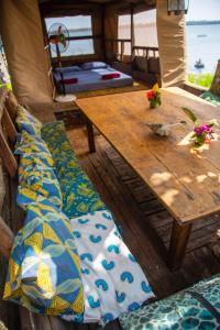 mesa y sillas con mesa de madera en Firefly Eco Retreat, en Shimoni