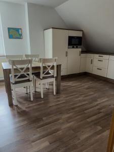 uma cozinha com mesa e cadeiras num quarto em „Kiekut“ Ferienwohnung em Fehmarn