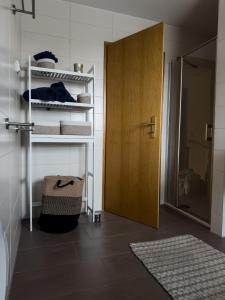um quarto com uma porta e uma prateleira com toalhas em „Kiekut“ Ferienwohnung em Fehmarn