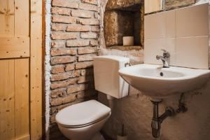 a bathroom with a white toilet and a sink at Country House Atelier in Zvoneće