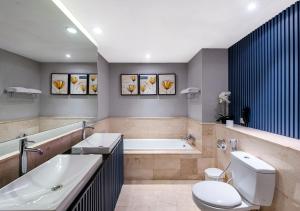 Un baño con bañera, inodoro y lavabo. en Oakwood Hotel & Apartments Taman Mini Jakarta, en Yakarta