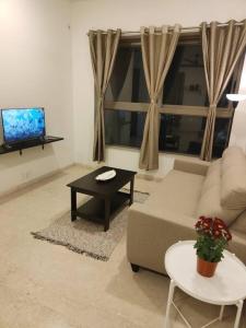 a living room with a couch and a table and a tv at Your Perfect Stay Awaits! in Thane