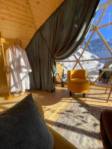 Zimmer mit einem Bett, einem Stuhl und einem Fenster in der Unterkunft Gabua Glamping in Kazbegi