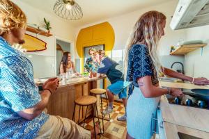 a group of people standing in a kitchen at La Boga L'Auberge à l'ambiance Surf à Biscarrosse Plage in Biscarrosse-Plage