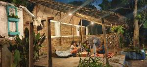 eine Gruppe von Menschen, die nachts auf einer Terrasse sitzen in der Unterkunft Dutch Square Hostel in Alappuzha