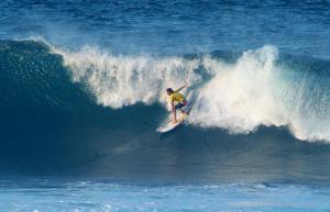 um homem a surfar uma onda numa prancha de surf no oceano em The Atlantis Historic Inn em Saint Joseph