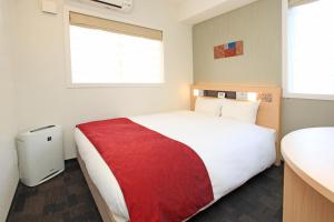 a bedroom with a large white bed with a red blanket at Urban Hotel Kyoto Nijo Premium in Kyoto