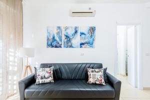 een zwarte leren bank in een woonkamer met een schilderij bij The Base - Comfort a Milano in Milaan