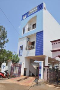 un edificio azul y blanco con una moto aparcada delante en SCK Home Stay, en Hyderabad