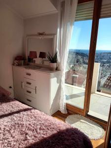1 dormitorio con ventana grande y vestidor con espejo en Sunset Rooms Dubrovnik, en Dubrovnik