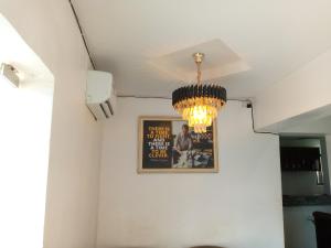ein Kronleuchter hängt an einer weißen Wand mit einem Bild in der Unterkunft Exclusive mansion lekki phase 1 in Ilado