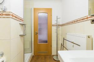 a bathroom with a sink and a wooden door at Ferienwohnung Schila in Boltenhagen