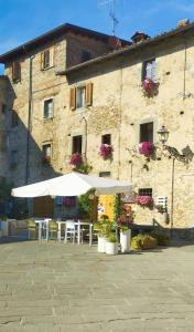 a patio with tables and umbrellas in front of a building at B&B Luna & Stelle in Villafranca in Lunigiana