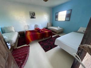 Cette chambre comprend un lit et un canapé. dans l'établissement Les Jardins d Amizmiz, à Marrakech