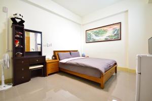 a bedroom with a bed and a dresser and a mirror at Fengru B&B in Taitung City